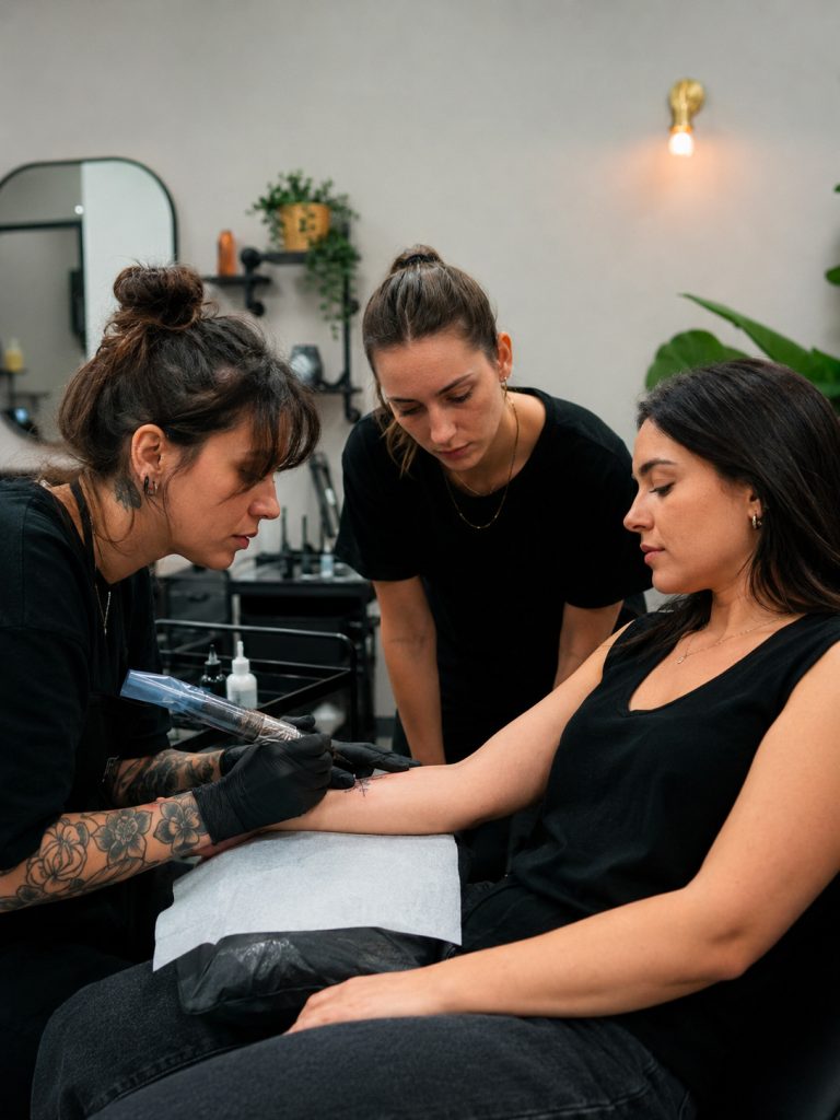Esercitazione pratica di minimal tattoo su avambraccio durante un corso professionale a Catania